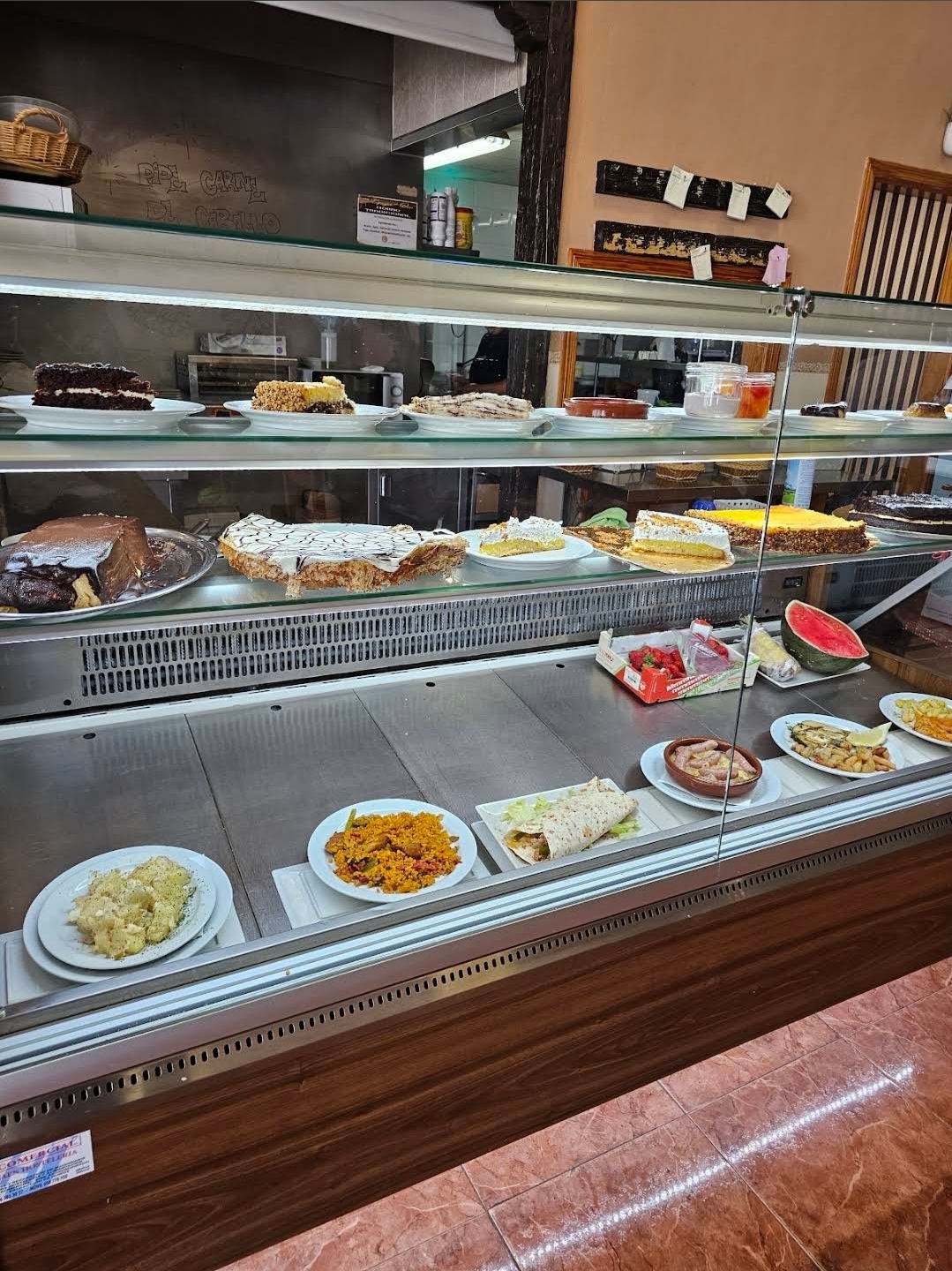 Mostrador y vitrina con tartas, postres y platos del día